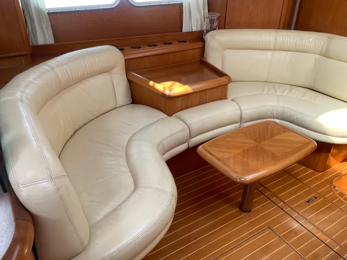 Jethro Yacht Photos Pics Luxurious interior of 2003 Jeanneau Sun Odyssey 54 DS with cream leather seating and wooden table.