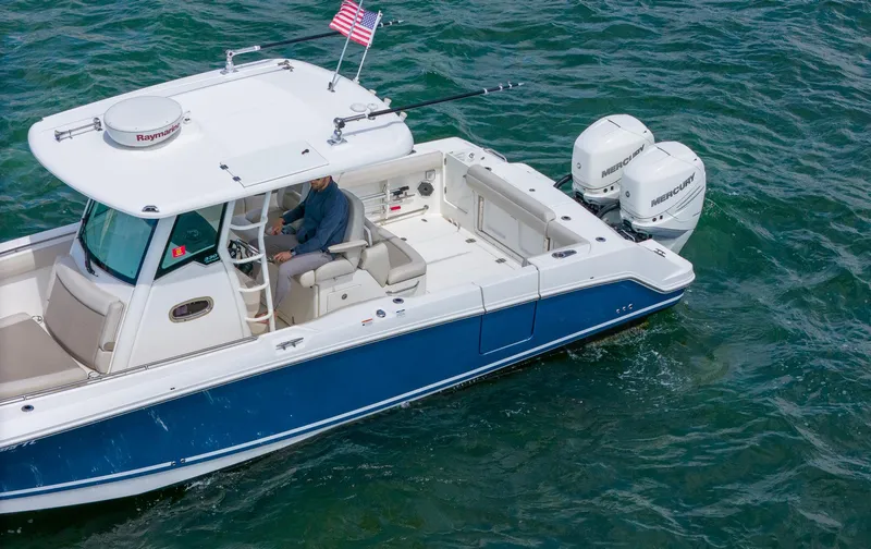 Rocco Yacht Photos Pics 2020 Boston Whaler 330 Outrage boat cruising on water with American flag.