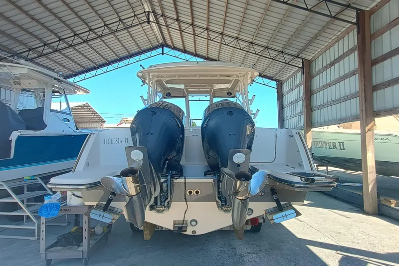 325-708 Brokerage Josh Yacht Photos Pics 2021 Grady-White Freedom 325 boat with dual outboard motors in a covered storage area.