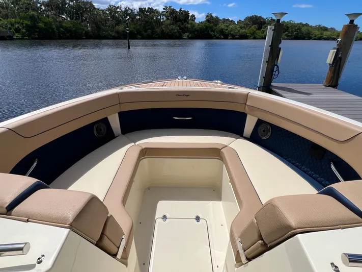 Yacht Photos Pics 2024 Chris-Craft Calypso 32 boat interior with tan seating, docked by a serene lake.