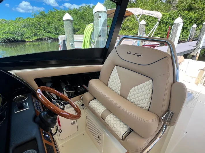  Yacht Photos Pics 2024 Chris-Craft Calypso 32 helm with luxurious seating and wooden steering wheel.