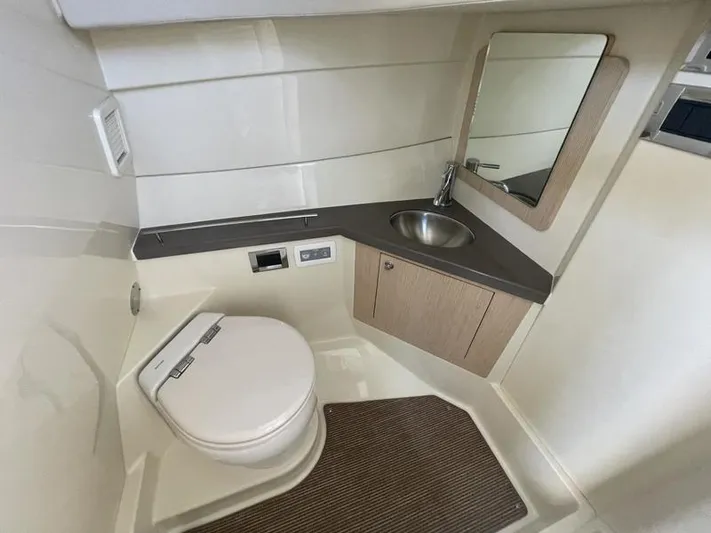  Yacht Photos Pics 2024 Chris-Craft Calypso 32 boat bathroom with toilet, sink, and mirror.