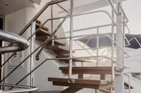 Modern staircase on 2024 Custom Canyon 92 yacht, featuring sleek metal railings and wooden steps.