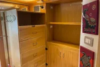 Wooden storage cabinets with drawers and shelves, decorative wall art, and ambient lighting.