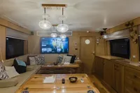 Luxurious yacht interior with modern decor, featuring a cozy seating area and entertainment system. Custom Canyon 92, 2024.