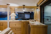 Luxurious interior of 2024 Custom Canyon 92 yacht with elegant wooden furnishings and ambient lighting.