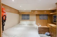 Luxurious cabin interior of 2024 Custom Canyon 92 yacht with cozy bed and wooden furnishings.