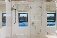 Modern bathroom with glass shower, white fixtures, and natural light in a 2024 Custom Canyon 92.