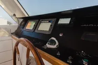Helm of 2024 Custom Canyon 92 yacht with navigation instruments and wooden steering wheel.