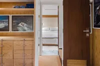 Luxurious interior of 2024 Custom Canyon 92 yacht with wooden decor and cozy bedroom.