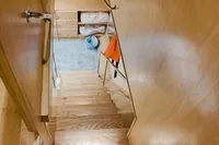 Wooden staircase in a Custom Canyon 92, 2024 model, leading to a cozy interior space.