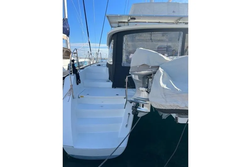  Yacht Photos Pics 2018 Lagoon 450 F catamaran with covered outboard motor and steps, docked in marina.