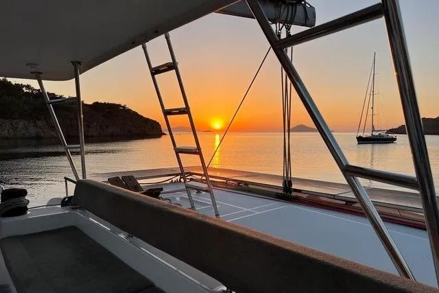  Yacht Photos Pics Lagoon 450 F catamaran at sunset, 2018 model, with scenic ocean view.