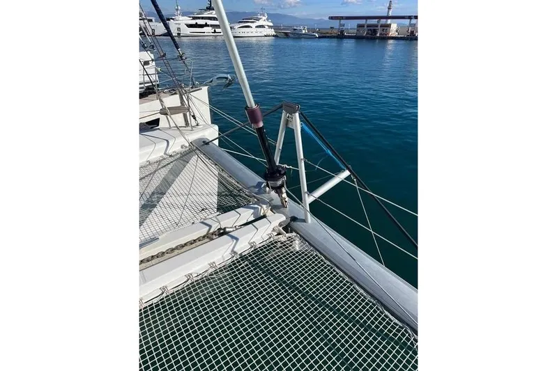  Yacht Photos Pics 2018 Lagoon 450 F catamaran deck with netting, docked in a marina.