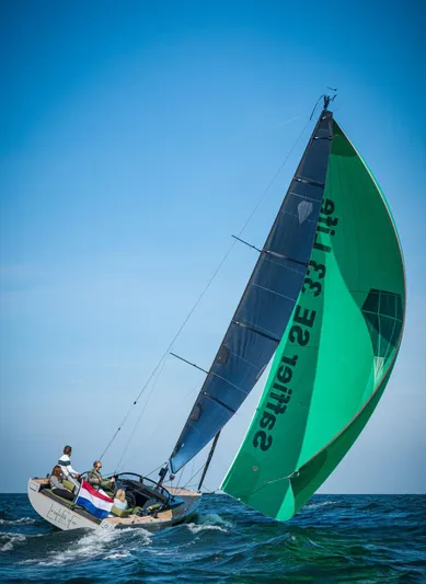  Yacht Photos Pics Saffier 33 Life sailboat navigating ocean waves, 2026 model, with vibrant green sail.