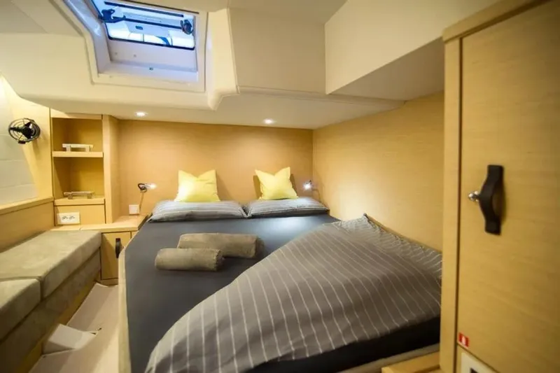  Yacht Photos Pics Luxurious cabin interior of 2016 Jeanneau 64 yacht with cozy bedding and modern design.