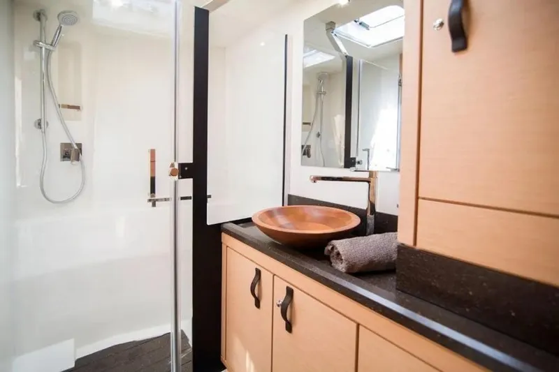  Yacht Photos Pics Luxurious bathroom in 2016 Jeanneau 64 yacht with modern fixtures and wooden accents.