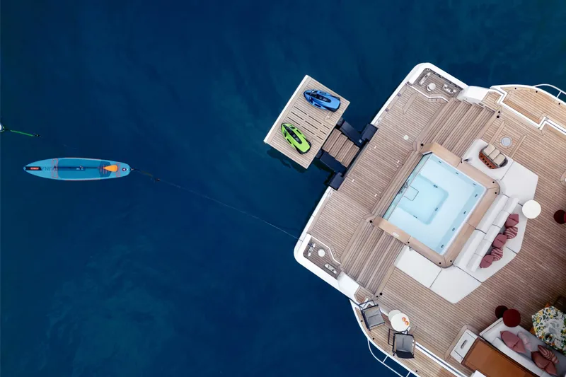 A+ Yacht Photos Pics Aerial view of 2024 Benetti Oasis yacht deck with jacuzzi and paddleboard.
