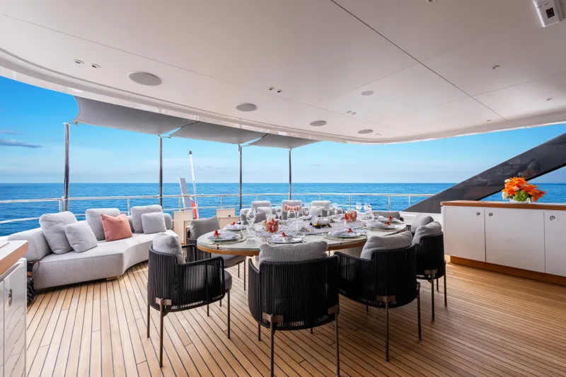 A+ Yacht Photos Pics Luxurious 2024 Benetti Oasis yacht deck with elegant dining setup and ocean view.