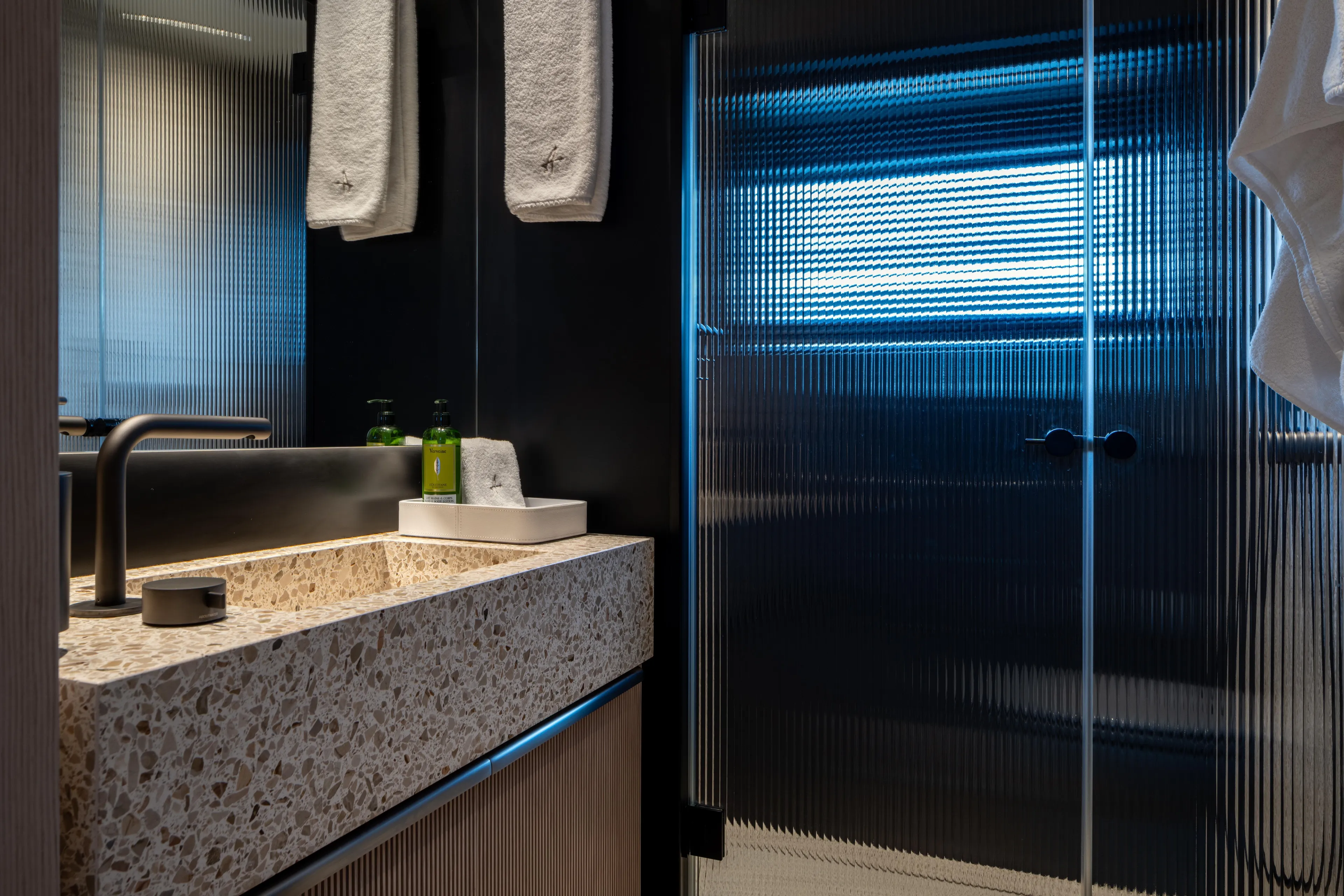 A+ Yacht Photos Pics Luxurious bathroom in 2024 Benetti Oasis yacht with modern sink and frosted glass shower.