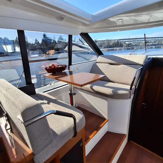  Yacht Photos Pics Modern interior of 2017 Jeanneau NC14 yacht with cozy seating and table.