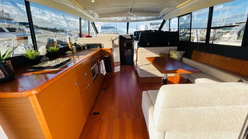  Yacht Photos Pics Interior of 2017 Jeanneau NC14 yacht with elegant wood finish and spacious seating.