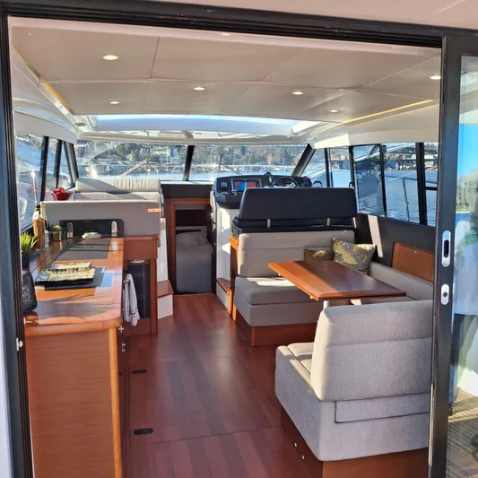  Yacht Photos Pics Interior of 2017 Jeanneau NC14 yacht with modern seating and wooden flooring.
