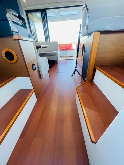  Yacht Photos Pics Interior of 2017 Jeanneau NC14 yacht with wooden flooring and modern seating.