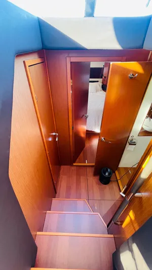  Yacht Photos Pics Interior view of 2017 Jeanneau NC14 yacht, featuring wooden stairs and doors.