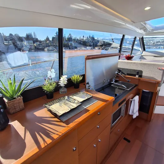  Yacht Photos Pics Modern kitchen interior of 2017 Jeanneau NC14 yacht with scenic water views.