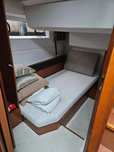  Yacht Photos Pics 2017 Jeanneau NC14 cabin interior with bed, pillows, and window.