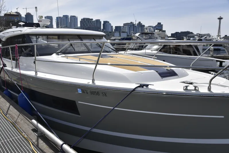  Yacht Photos Pics 2017 Jeanneau NC14 yacht docked with city skyline in background.