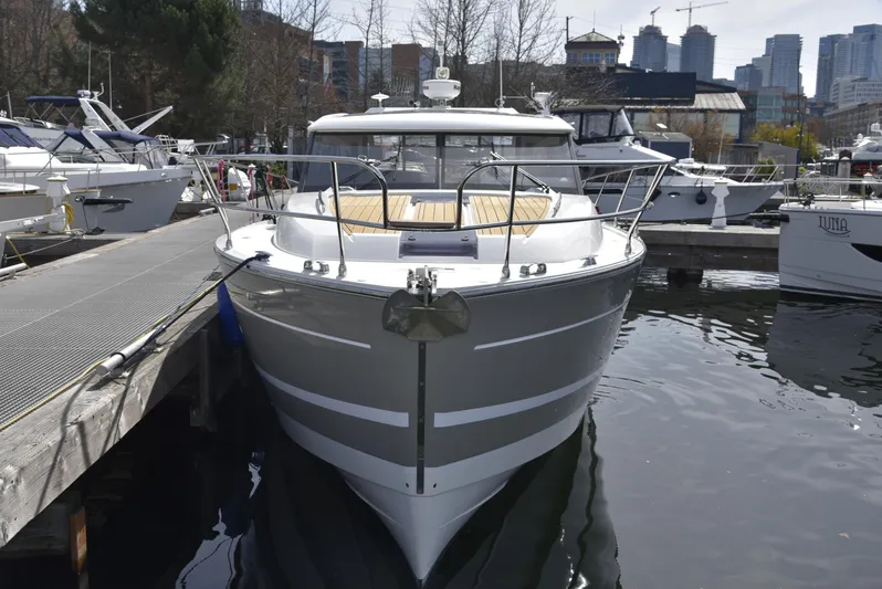  Yacht Photos Pics 2017 Jeanneau NC14 yacht docked at marina, surrounded by other boats and city skyline.