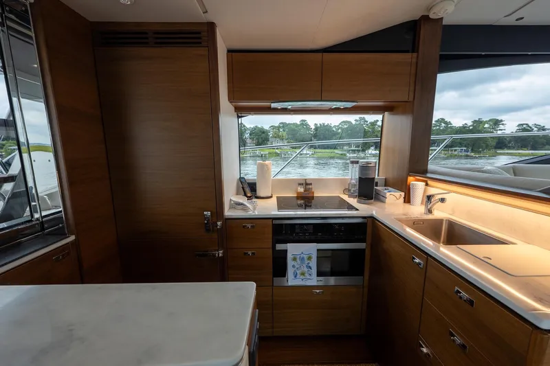 Regent Yacht Photos Pics Luxurious kitchen interior of 2021 Princess S62 yacht with modern appliances and scenic window view.