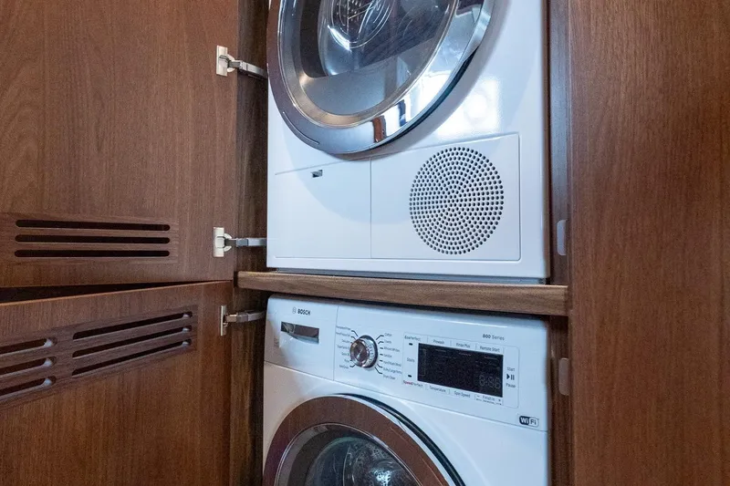 Regent Yacht Photos Pics Stacked washer and dryer in wooden cabinet on Princess S62 yacht, 2021 model.