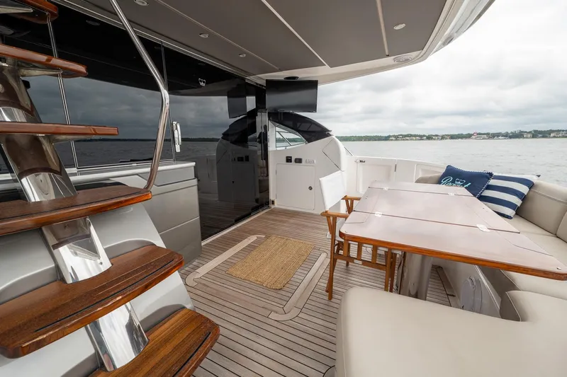 Regent Yacht Photos Pics Luxurious 2021 Princess S62 yacht deck with wooden stairs, seating, and ocean view.