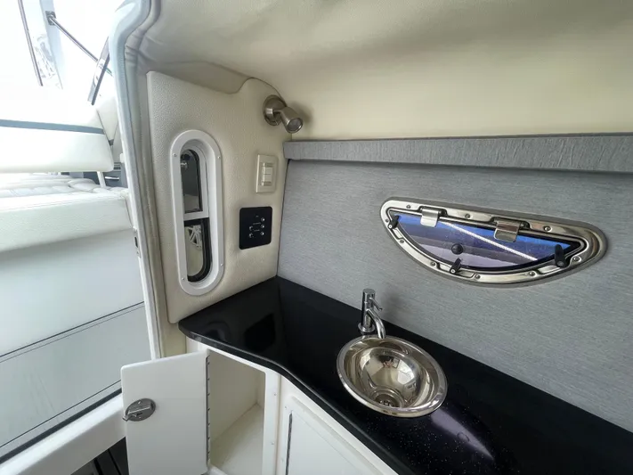  Yacht Photos Pics 2022 Cobalt 30SC boat interior with sink and porthole window.