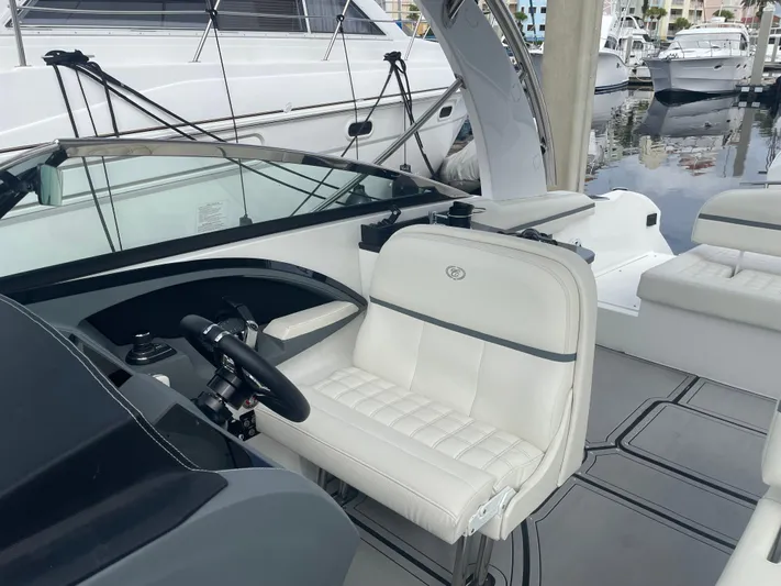  Yacht Photos Pics 2022 Cobalt 30SC boat interior with white seating and steering wheel at marina.