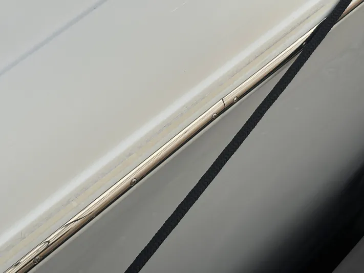  Yacht Photos Pics Close-up of 2022 Cobalt 30SC boat hull with sleek design and black strap.