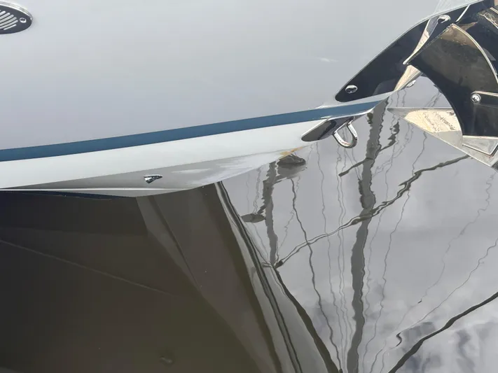  Yacht Photos Pics Close-up of 2022 Cobalt 30SC boat hull reflecting on water.