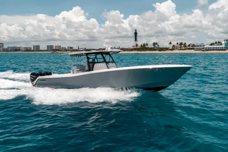  Yacht Photos Pics 2020 Invincible 39 Open Fisherman boat cruising on blue ocean near coastline.