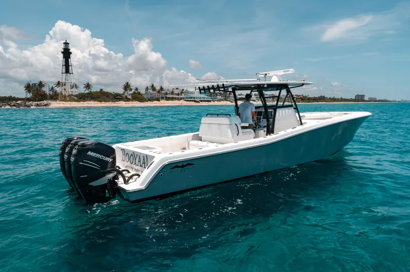  Yacht Photos Pics 2020 Invincible 39 Open Fisherman boat on clear blue water near a lighthouse.