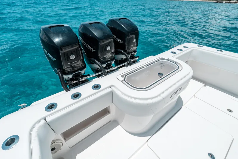  Yacht Photos Pics 2020 Invincible 39 Open Fisherman boat with triple Mercury engines on clear blue water.