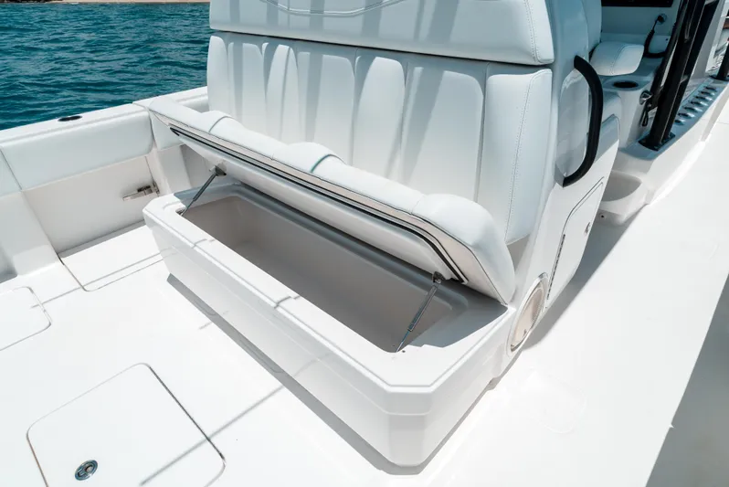  Yacht Photos Pics Open storage compartment on 2020 Invincible 39 Open Fisherman boat, white seating, ocean background.
