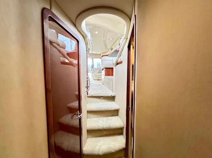 Slim Smitty Yacht Photos Pics Interior staircase of 2002 Sea Ray 560 Sedan Bridge yacht, featuring elegant design and plush carpeting.