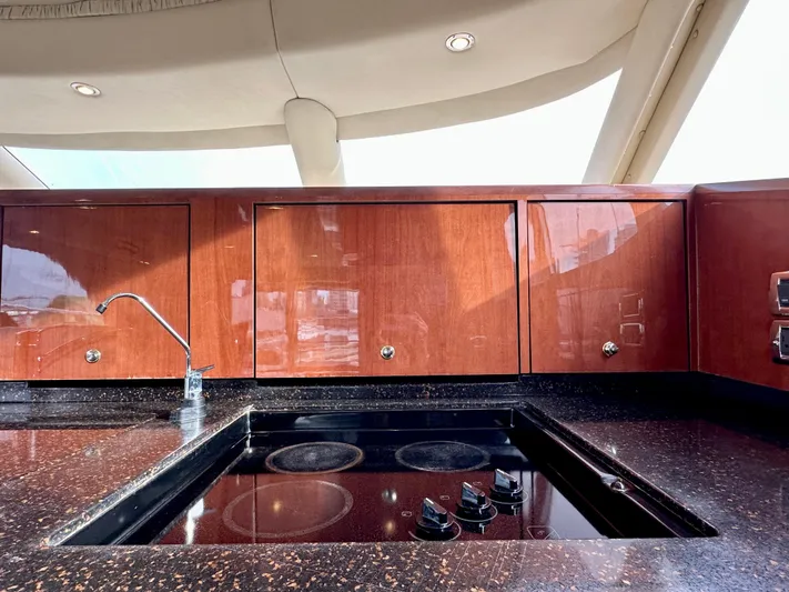 Slim Smitty Yacht Photos Pics Luxurious kitchen area on a 2002 Sea Ray 560 Sedan Bridge yacht with sleek wood cabinetry.