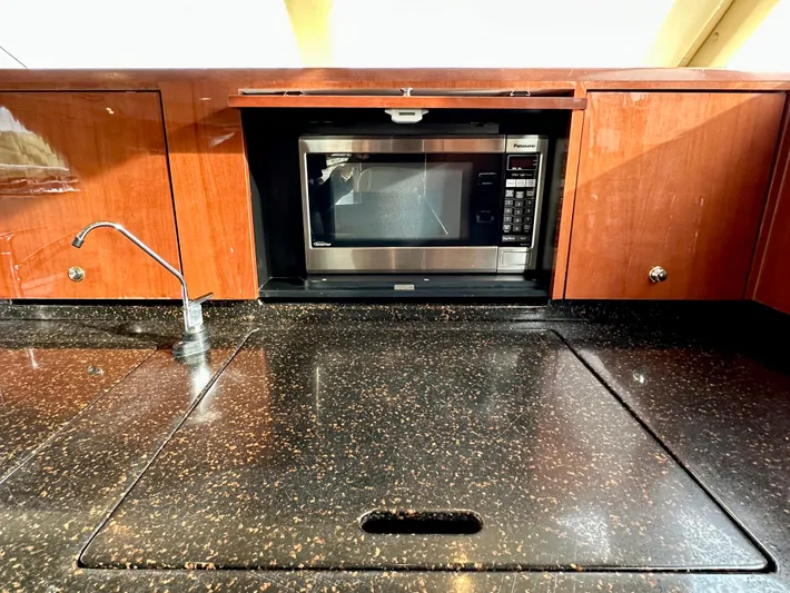 Slim Smitty Yacht Photos Pics 2002 Sea Ray 560 Sedan Bridge kitchen with microwave and sleek countertop.