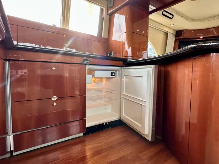 Slim Smitty Yacht Photos Pics Interior of 2002 Sea Ray 560 Sedan Bridge yacht, featuring open fridge and wooden cabinetry.