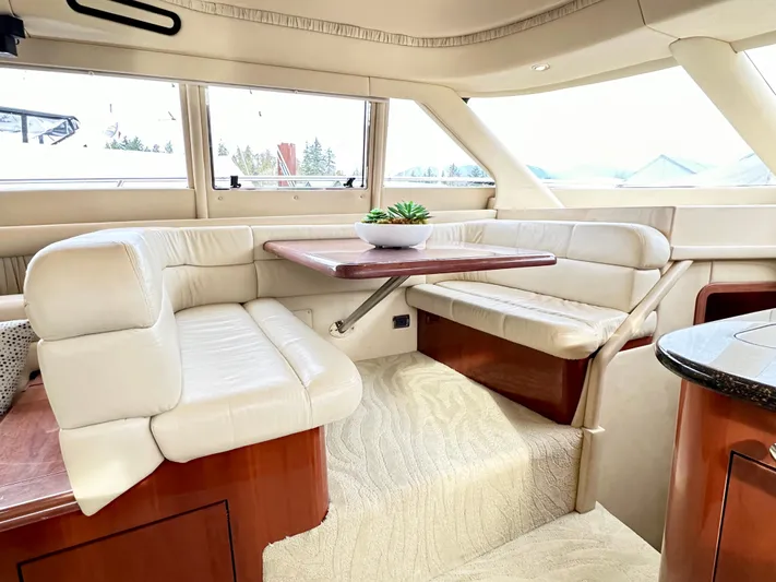 Slim Smitty Yacht Photos Pics Luxurious interior of 2002 Sea Ray 560 Sedan Bridge with plush seating and elegant table.