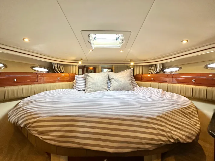 Slim Smitty Yacht Photos Pics Luxurious cabin interior of 2002 Sea Ray 560 Sedan Bridge yacht with striped bedding.